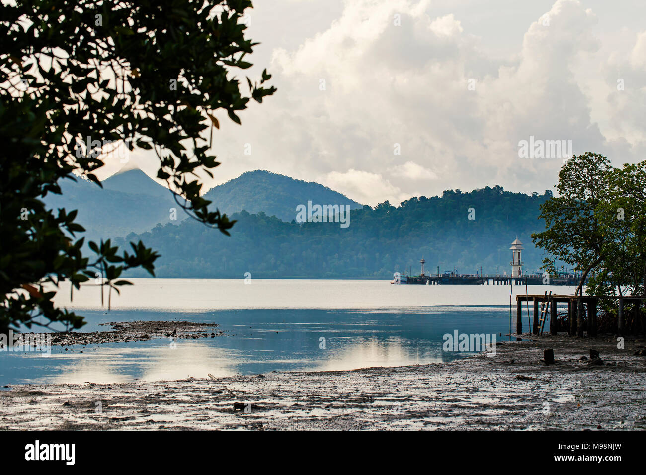 Porto di mattina con vedute delle montagne e nuvole.con silhouette di mangrovie. Foto Stock