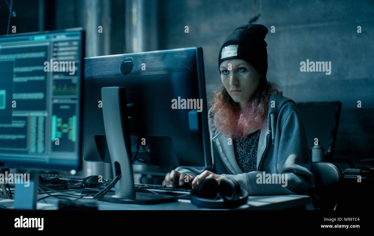Anticonformista adolescente ragazza Hacker attacchi e hack server aziendali con virus. La camera è scuro, Neon e ha molti Monitor e cavi. Foto Stock