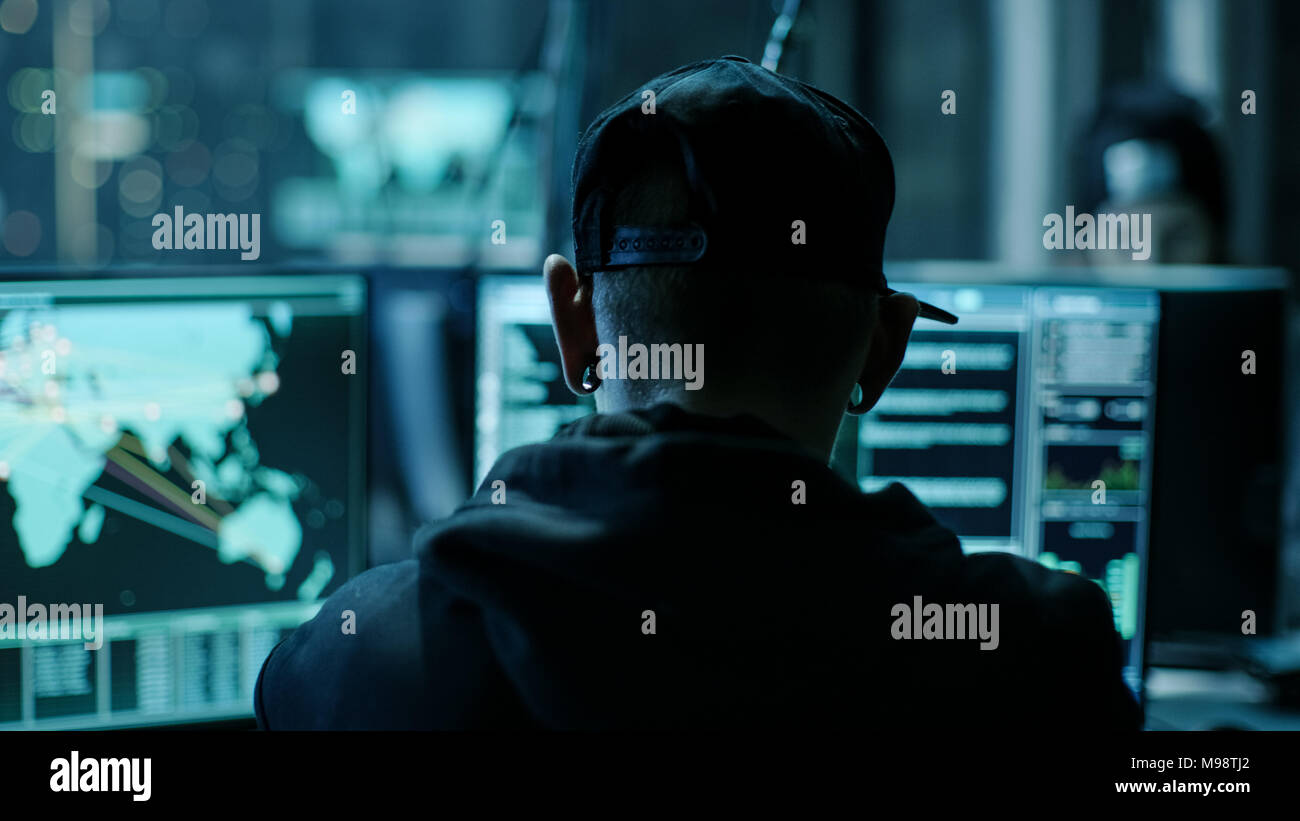 Close-up il telaio dal retro del lavoro Organizzazione di Hacker avanzate di attacco di virus su server aziendali. Luogo è scuro e ha più display. Foto Stock