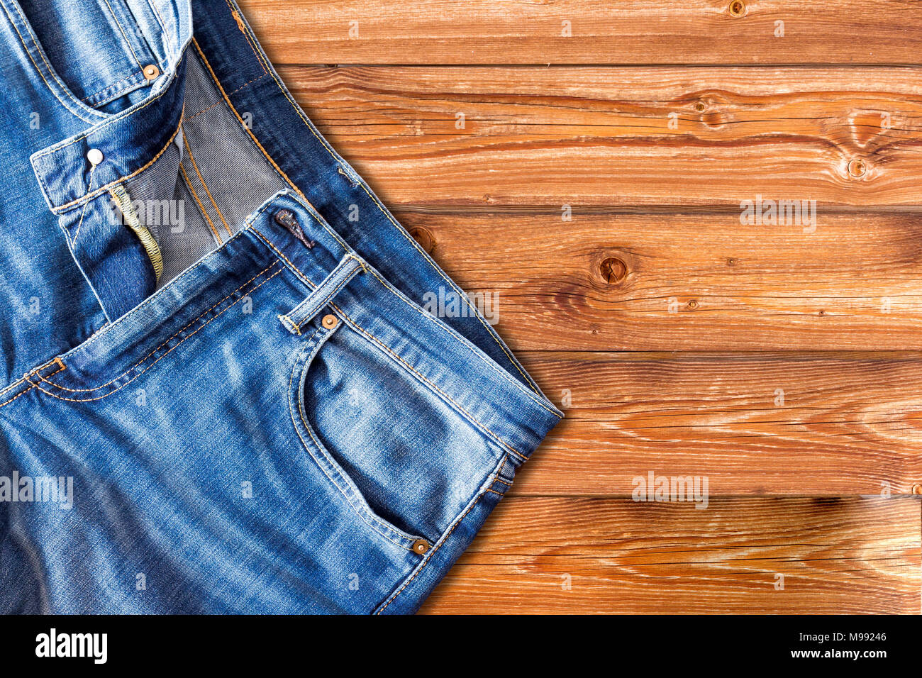 Close up di jeans pantaloni su sfondo di legno Foto Stock