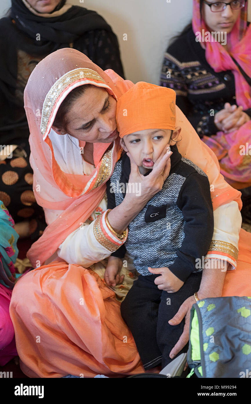 Nonna e nipote in preghiera presso il Gurdwara Sikh Società culturale nel sud Richmond Hill, Queens, a New Yok Foto Stock