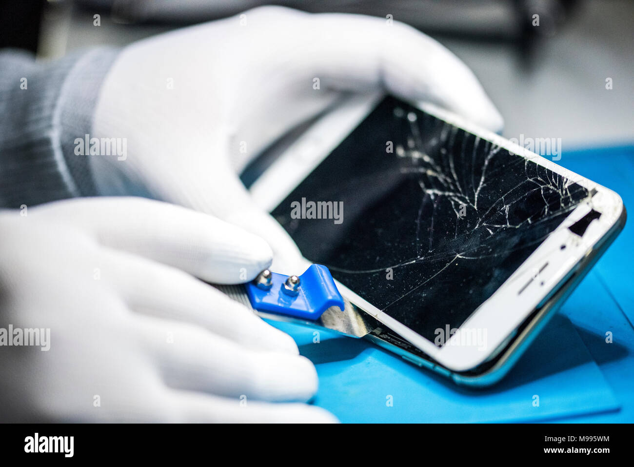 Le riparazioni di dispositivi elettronici, mani e gli attrezzi fissi, cellulari e computer Foto Stock