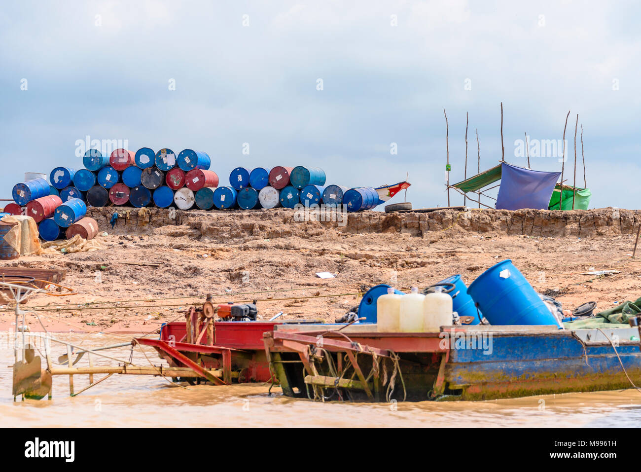 Fusti di plastica impilate sulla banca del Fiume Siem Reap, Cambogia. Foto Stock