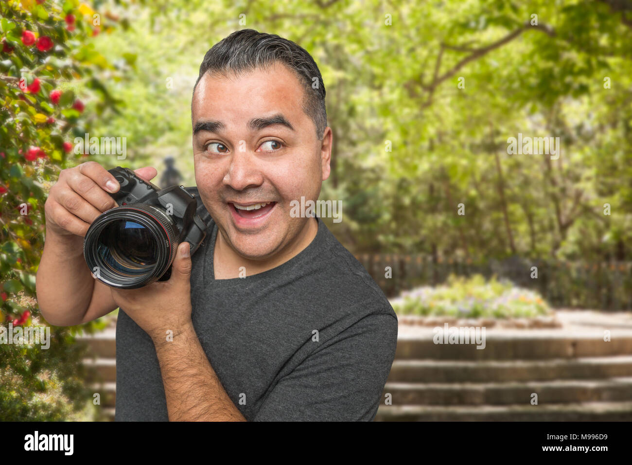 Ispanico maschio giovane fotografo con fotocamera DSLR all'aperto Foto Stock