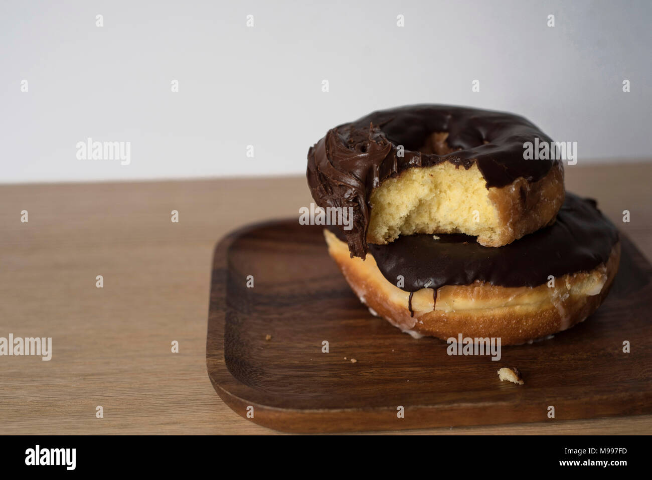 Ciambelle torta che qualcuno ha preso un morso fuori su uno sfondo luminoso Foto Stock