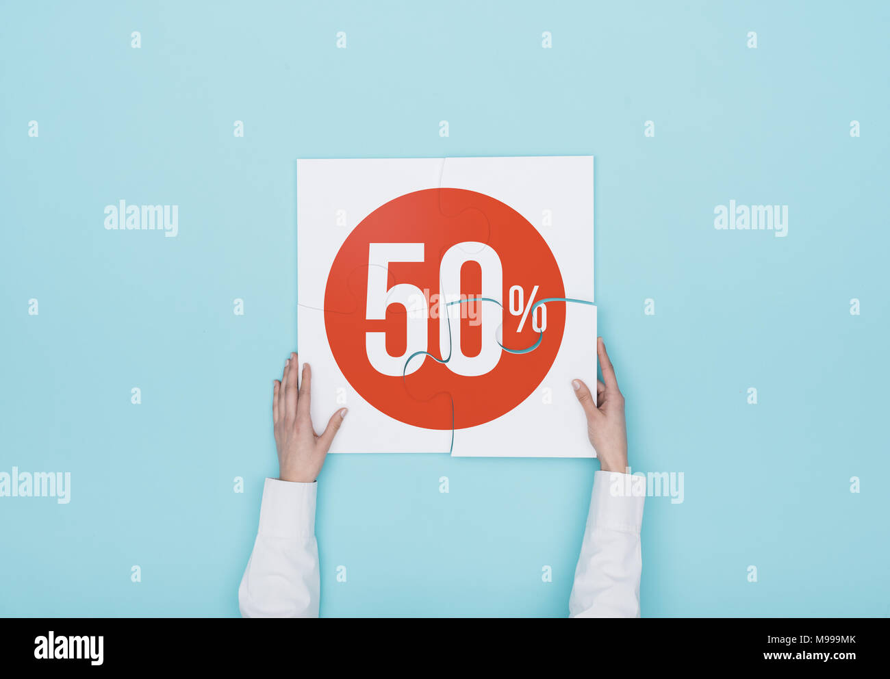 Donna completando un puzzle con un 50% di sconto icona, lei sta mettendo il pezzo mancante, shopping e sconti concept Foto Stock