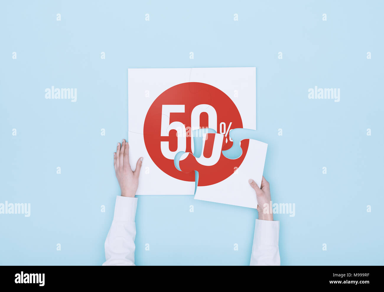Donna completando un puzzle con un 50% di sconto icona, lei sta mettendo il pezzo mancante, shopping e sconti concept Foto Stock