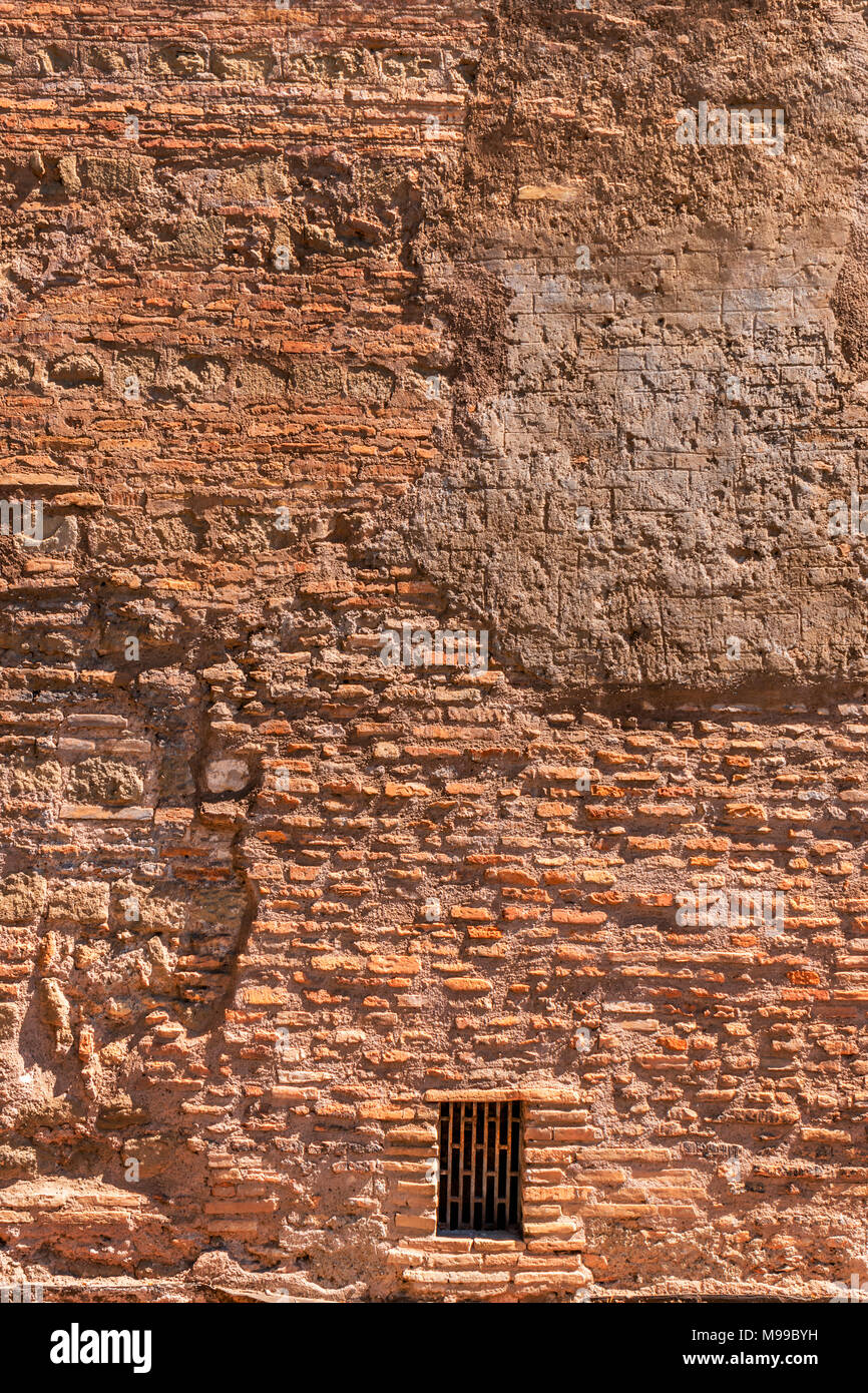 Texture di parete di mattoni e cemento con marcature e definizione di ombra con arrugginito metallo rettangolare di sfiato in Roma Foto Stock
