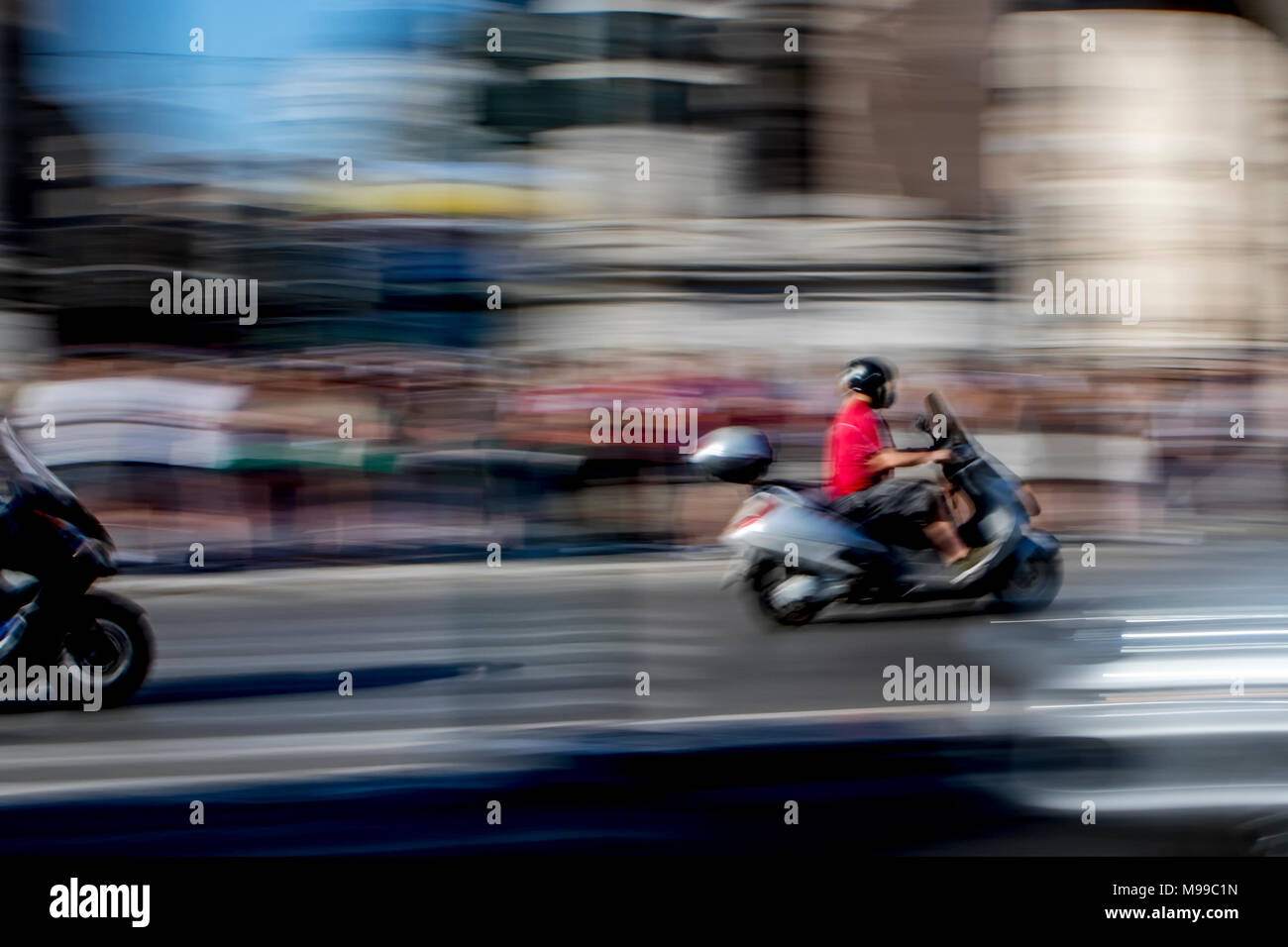 I motociclisti accelerando lungo la strada trafficata in Roma catturato per mostrare la velocità e azione e sfondo astratto Foto Stock