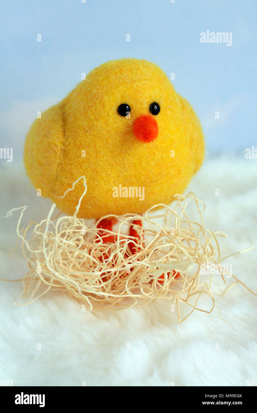 Agriturismo giallo animali adorabili poco pulcino di bambino nel nido formato verticale con materiale di annidamento intorno alle sue gambe nuvole sfondo e fondo bianco Foto Stock