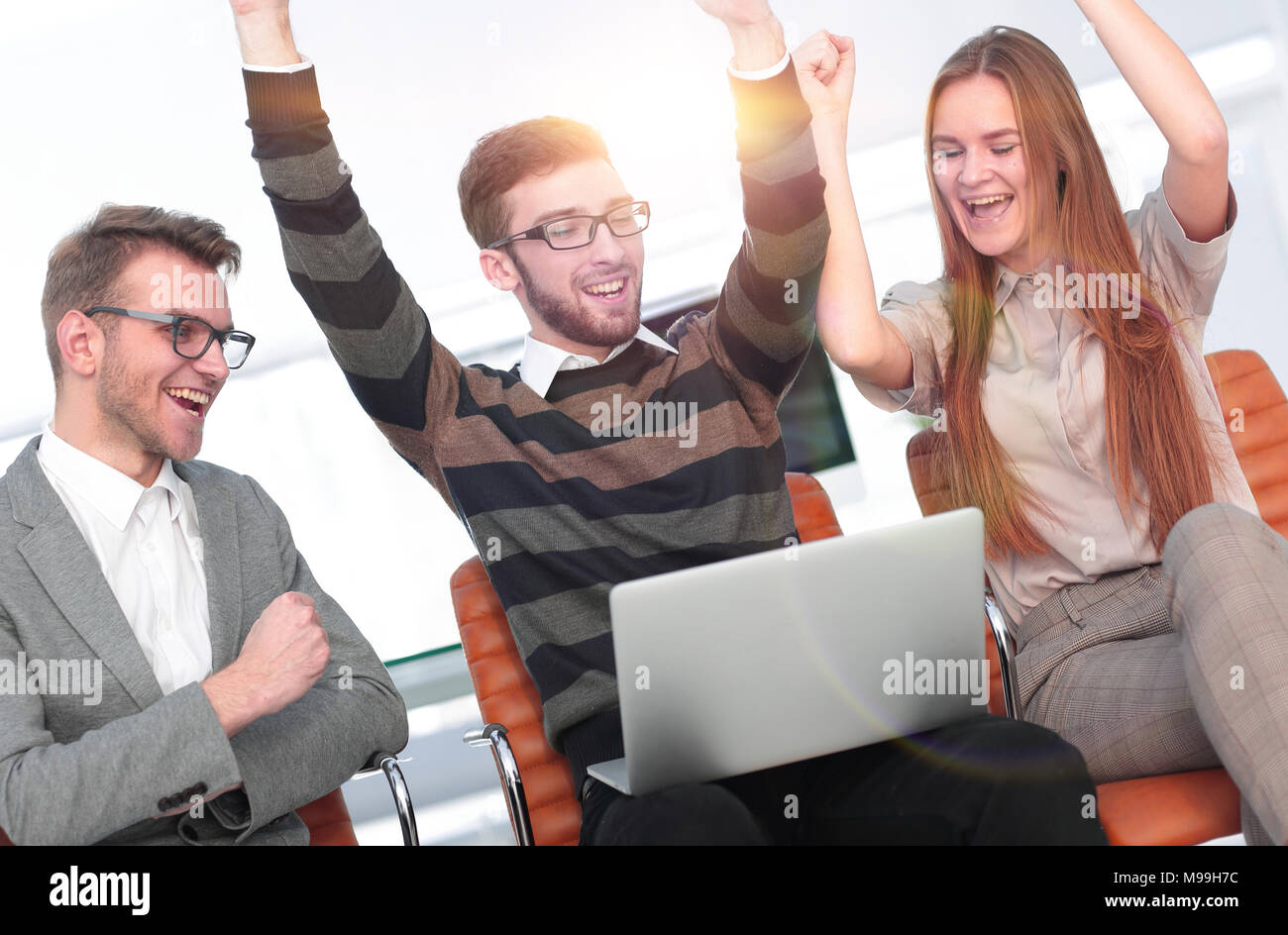 Tre dipendenti eccitati ricevendo buone notizie insieme sulla linea Foto Stock