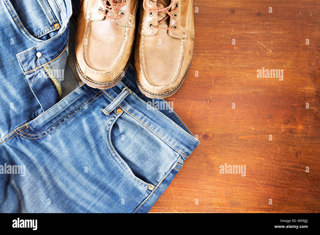 Close up dei pantaloni jeans e scarpe da uomo su sfondo di legno Foto Stock