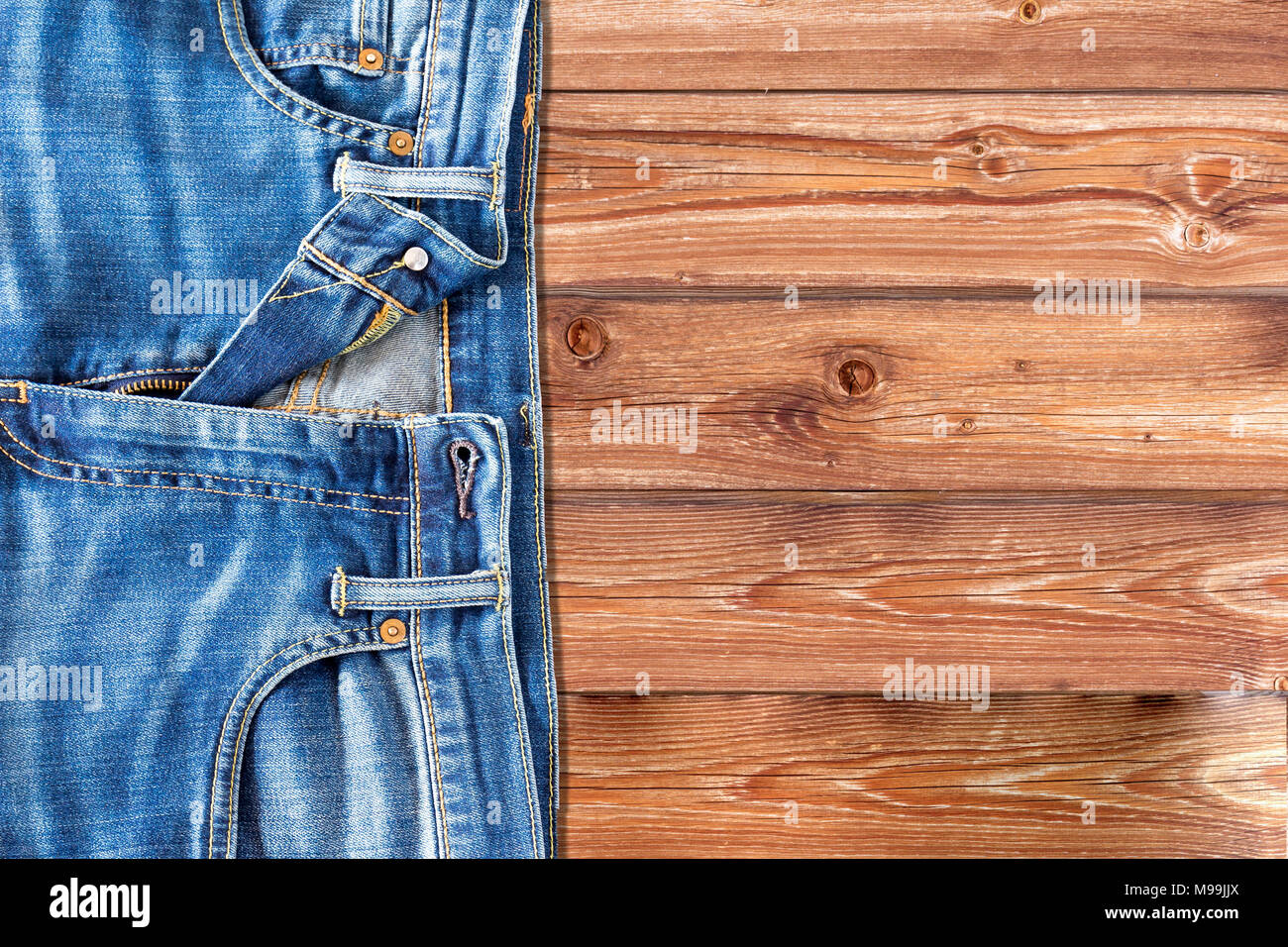 Close up di jeans pantaloni su sfondo di legno Foto Stock