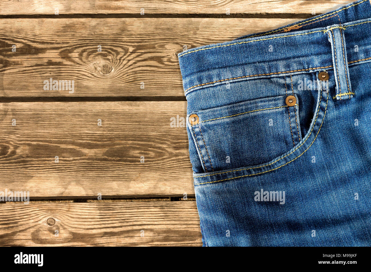 Close up di jeans pantaloni su sfondo di legno Foto Stock