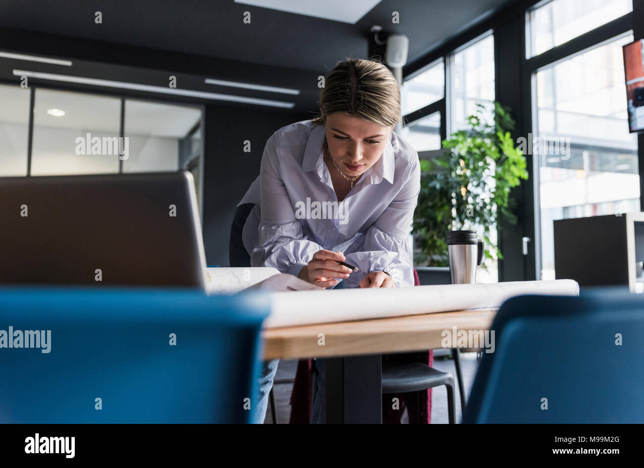Giovane donna che lavorano sul piano nella tabella in ufficio Foto Stock