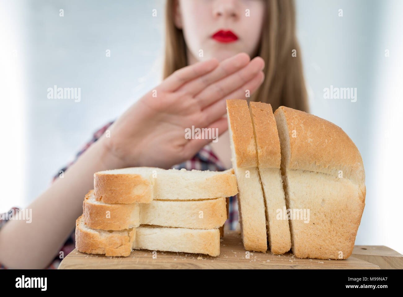Intolleranza al glutine di concetto. Giovane ragazza si rifiuta di mangiare il pane bianco - profondità di campo - Il fuoco selettivo sul pane Foto Stock