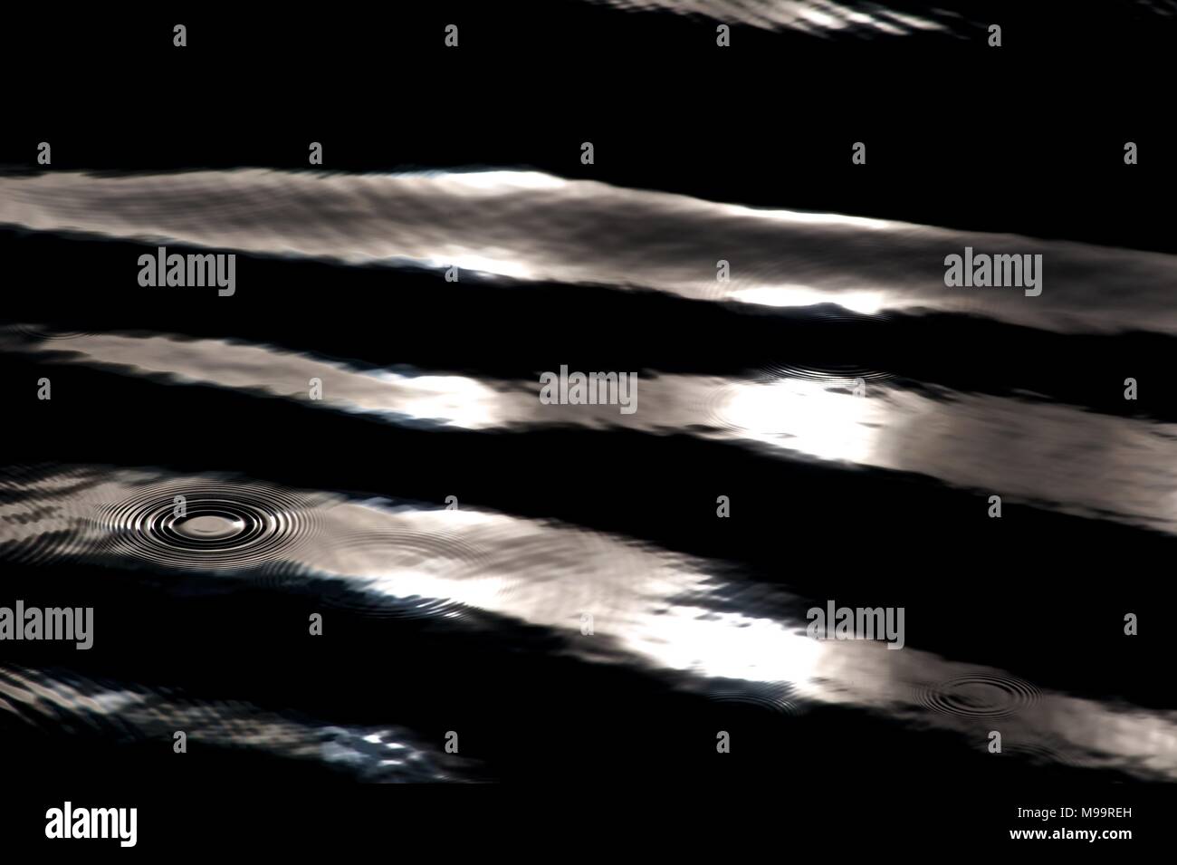 Acqua nera luce solare ripple circolare Foto Stock