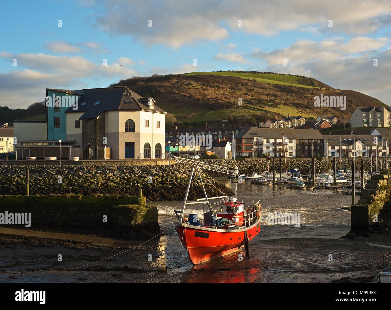 Il porto ed il lungomare di Aberystwyth Wales Febbraio 2013, con il rosso barca da pesca Foto Stock