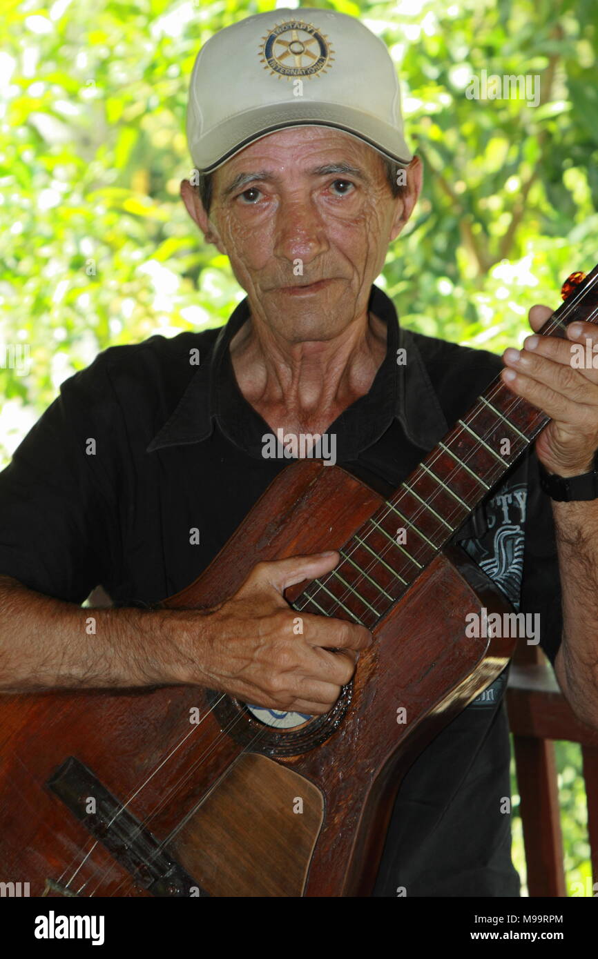 Ritratto di uomo cubano nel 60s con un cappuccio, tenendo in mano la sua chitarra davanti a lui. Foto Stock
