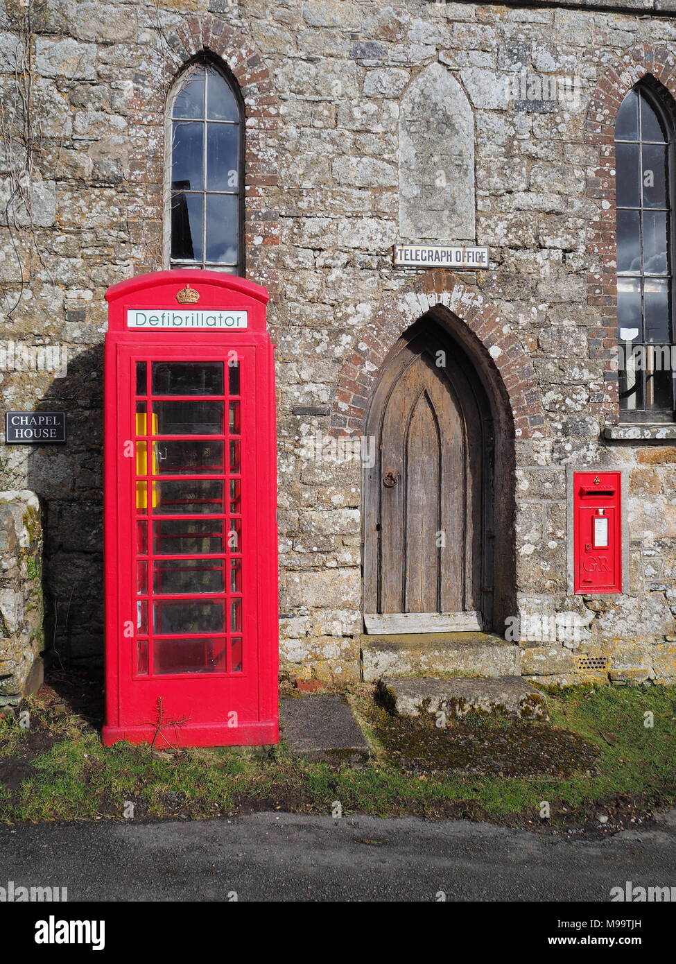 Tradizionale in rosso British telefono pubblico scatola contenente una unità di defibrillazione, Dartmoor Foto Stock