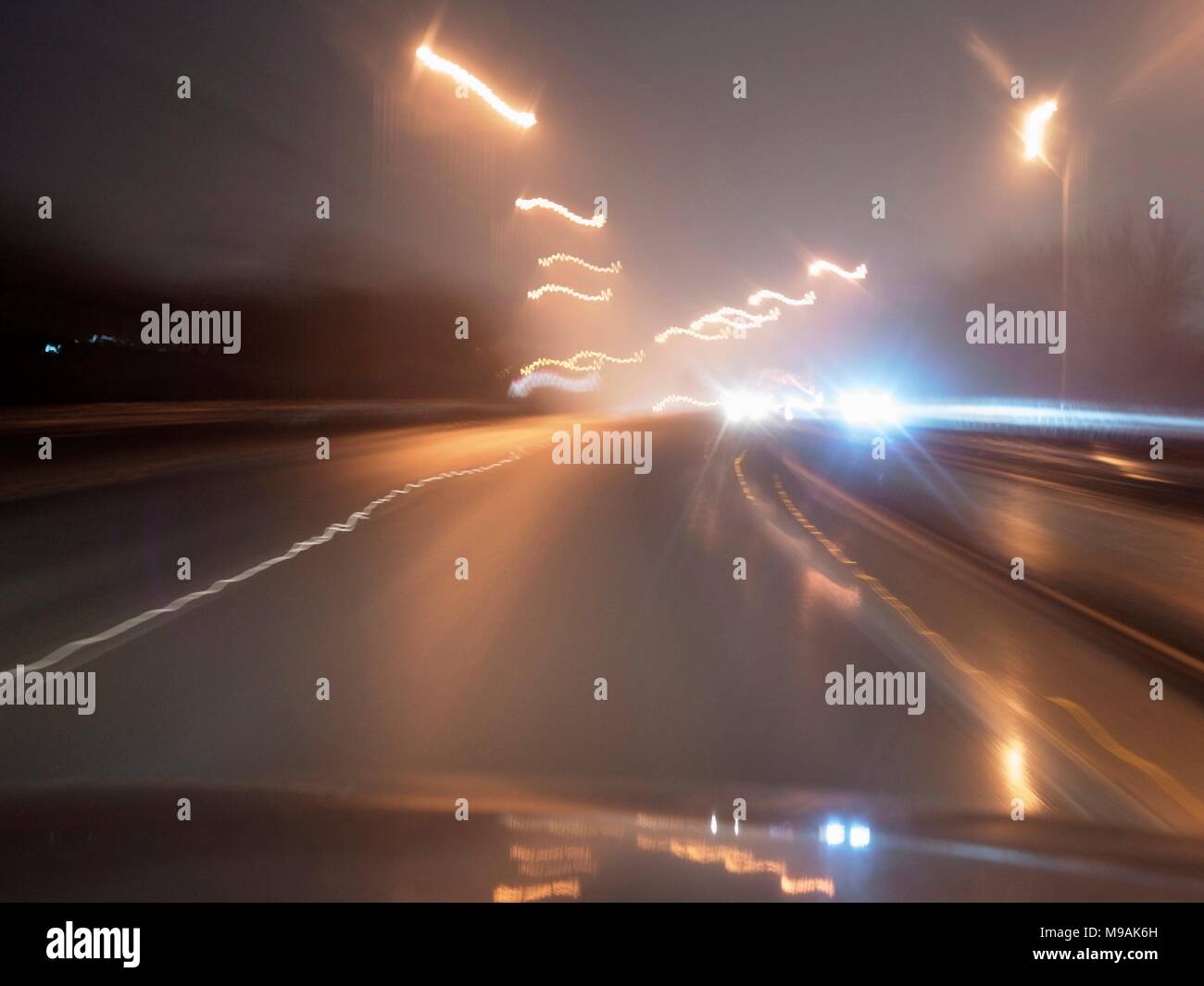 AJAXNETPHOTO. 2018. Autostrada M23, Inghilterra. - Abbagliamento dei fari - luci accecanti di su-proveniente traffico autostradale su una notte piovosa. foto:JONATHAN EASTLAND/AJAX REF:GXR180303 6946 Foto Stock