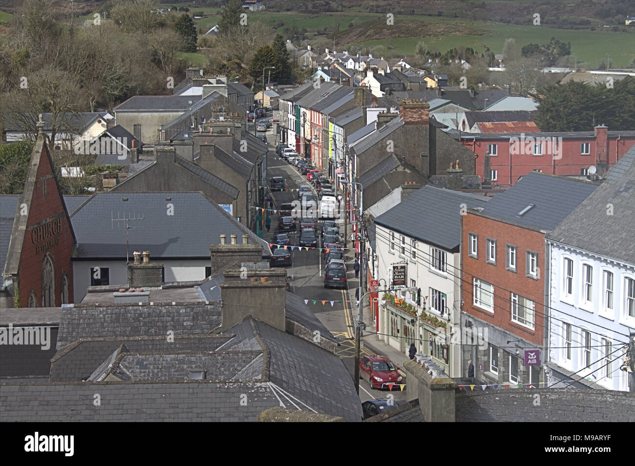 Guardando verso il basso sulla skibbereen, Irlanda main street con case in lontananza, con la bunting lasciati da san patrizio giorno. Foto Stock