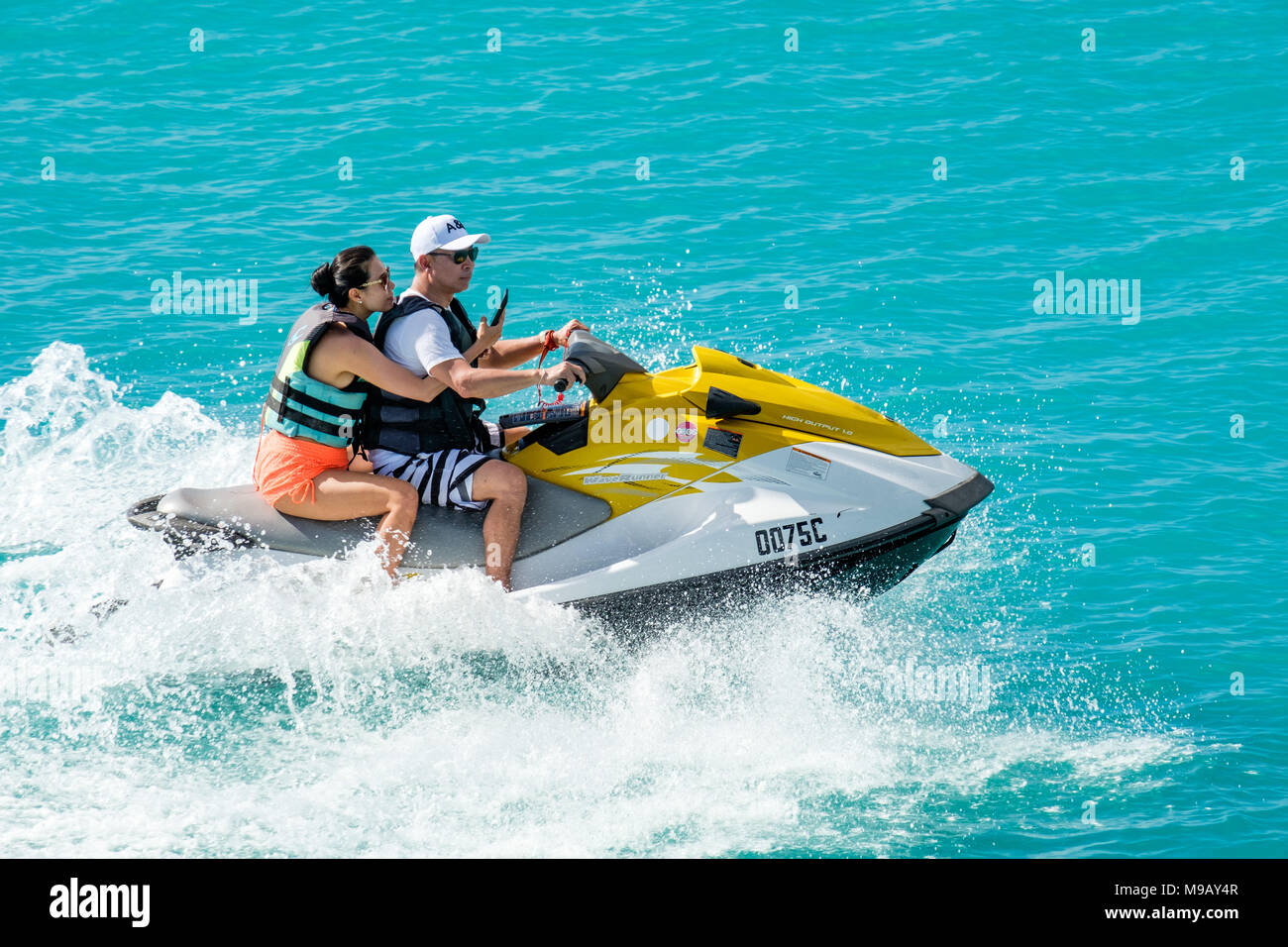 Turista giovane sul jet ski, Cocobay Antigua Foto Stock