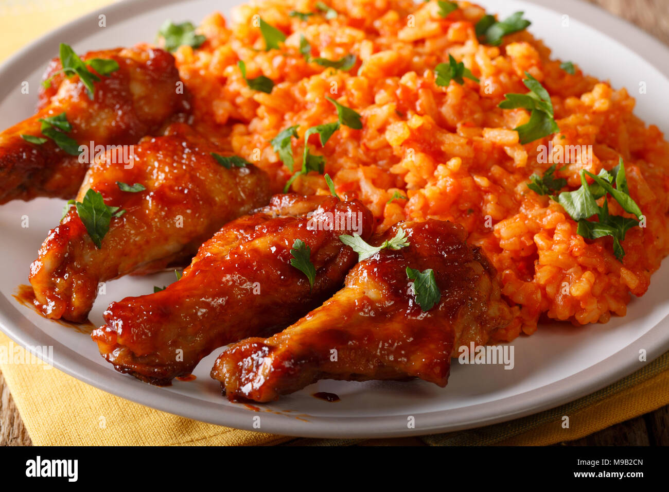 Cibo nigeriano: Jollof piccante di riso con pollo fritto closeup su una piastra orizzontale. Foto Stock