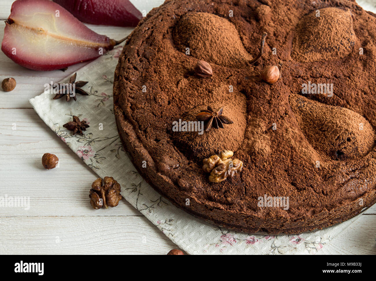 Cacke al cioccolato con pere stufati nel vino rosso, nocciole, noci. Dolce tradizionale. Foto Stock