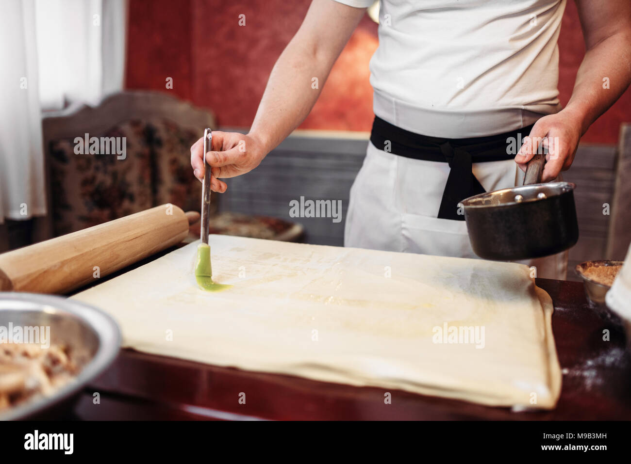 Maschio di cucina dello chef lo strudel di mele in cucina Foto Stock