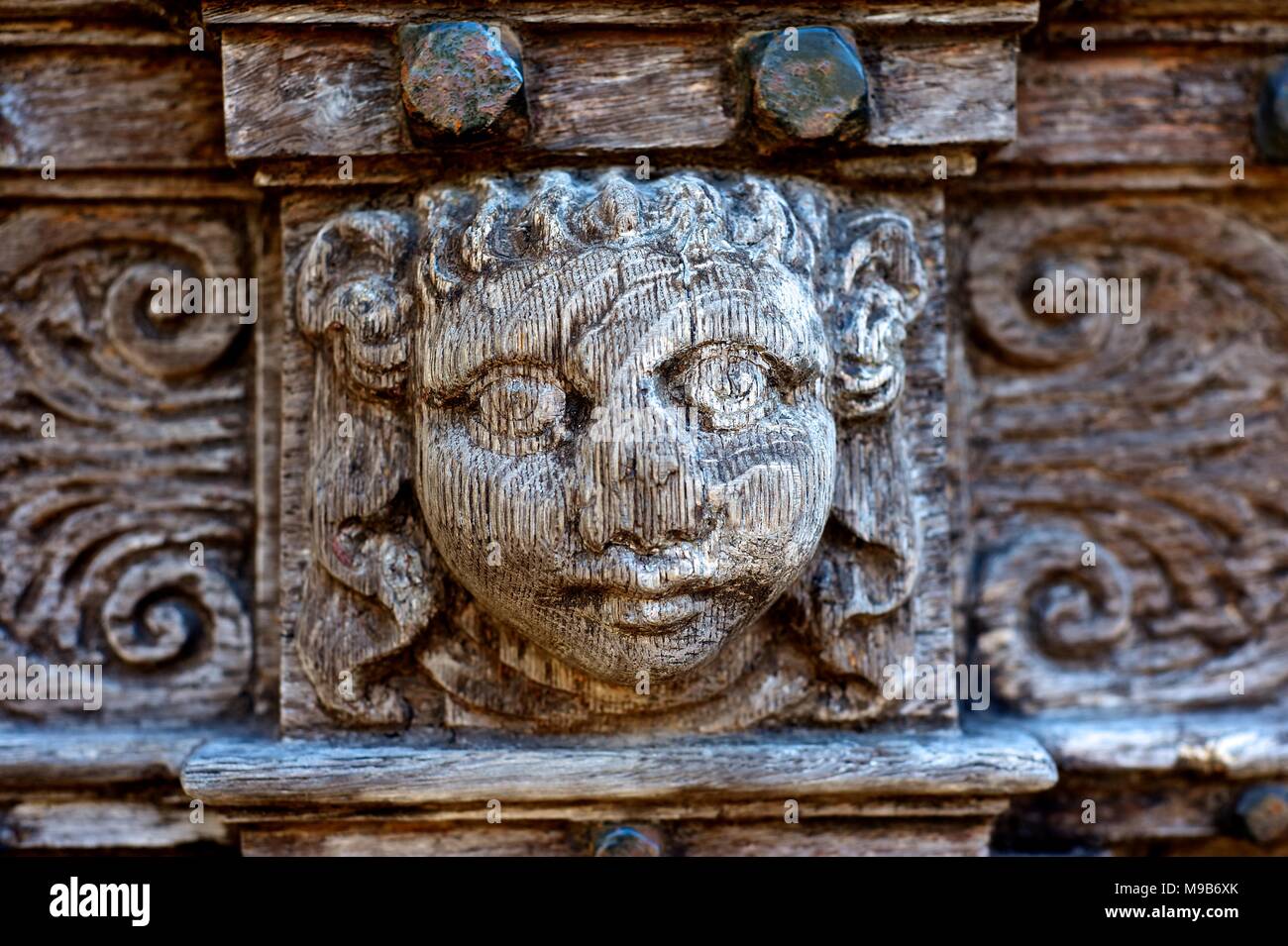 Intaglio del legno di facce su porte medievali Foto Stock