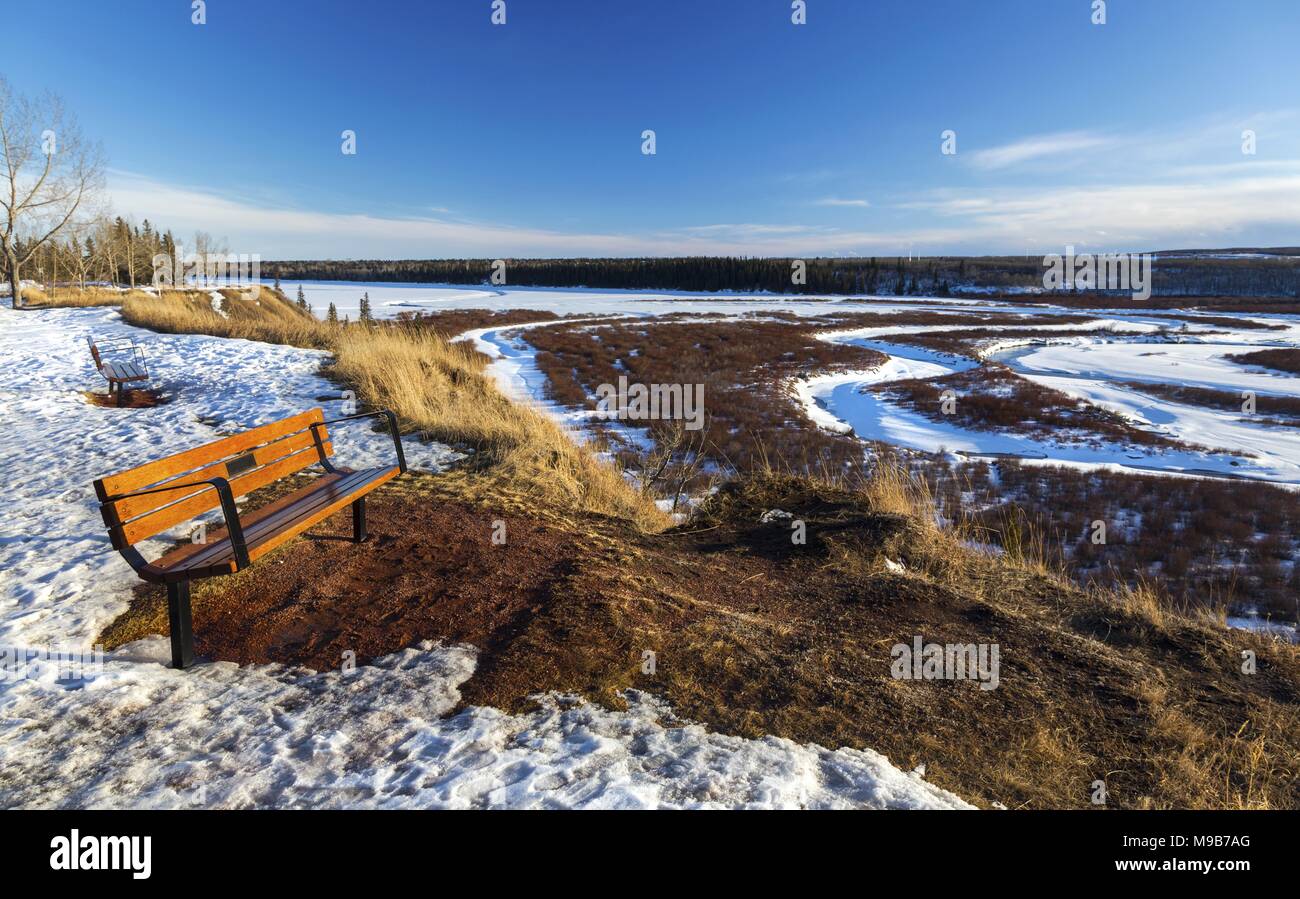 Parco isolato da banco e distante Snowy Glenmore serbatoio paesaggio panoramico a sud di Calgary Alberta a inizio primavera pomeriggio soleggiato Foto Stock