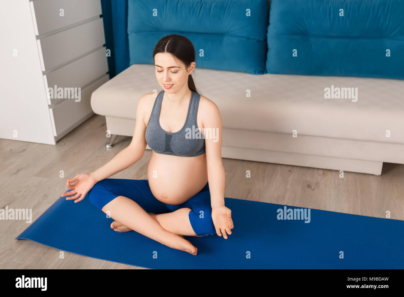Donna incinta medita Foto Stock