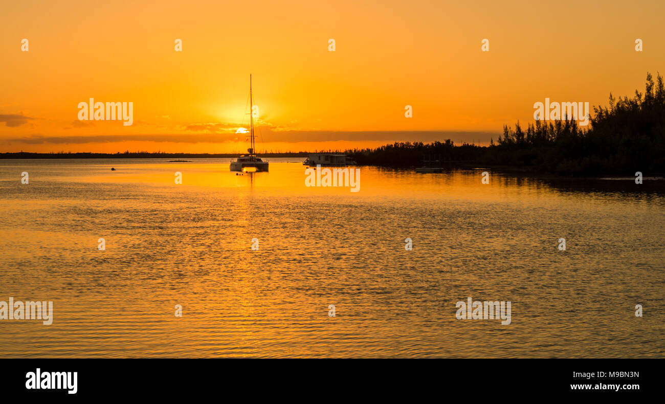 Sunrise delle Bahamas oltre oceano stupenda mostra catamarano a vela e la linea costiera Foto Stock