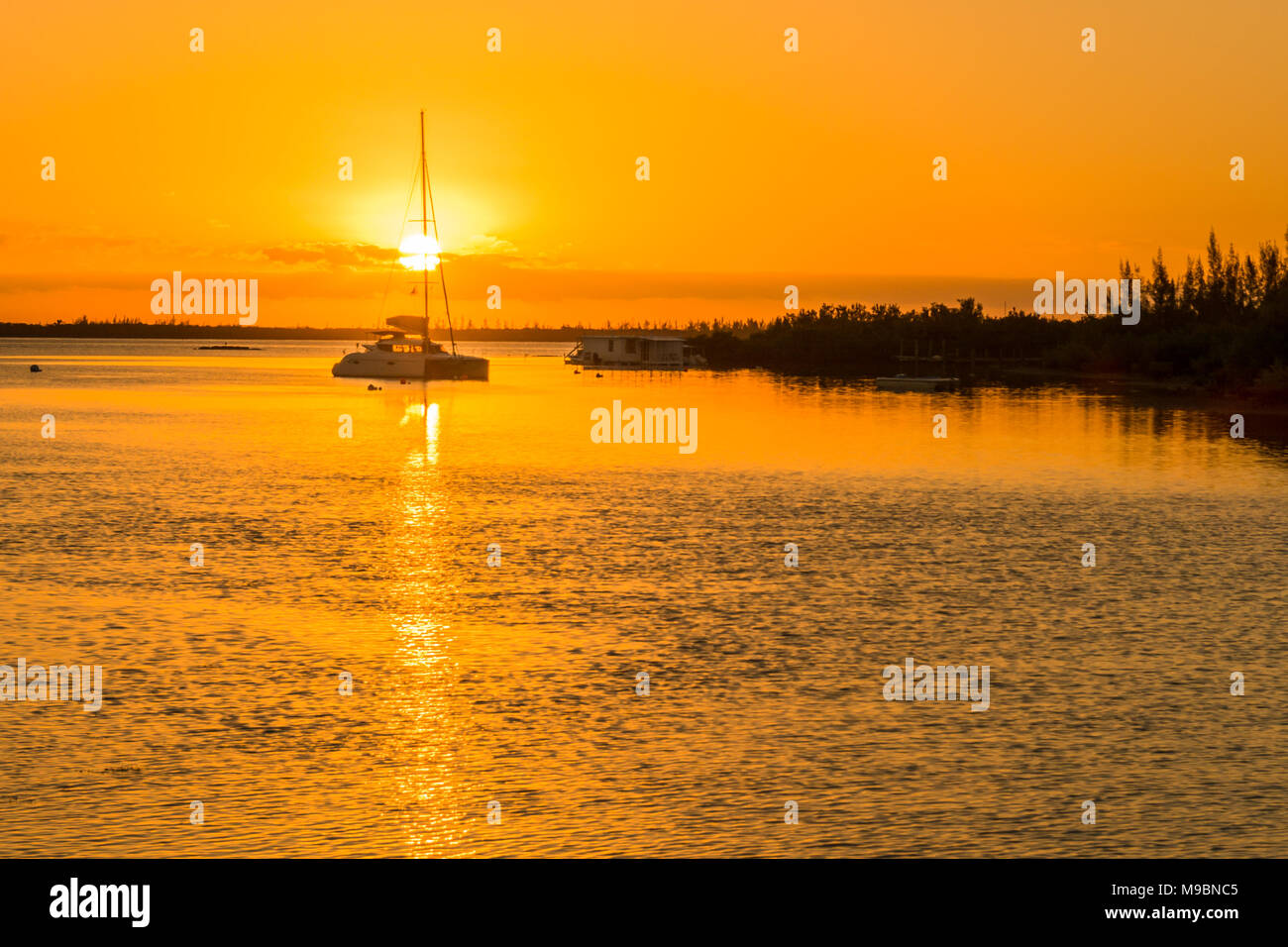 Sunrise delle Bahamas oltre oceano stupenda mostra catamarano a vela e la linea costiera Foto Stock