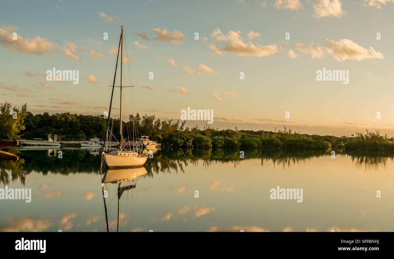 Lago di acqua salata in una bella e soleggiata giornata windless mostra velieri con riflessione speculare sul lago di acqua e mangrovie sullo sfondo Foto Stock