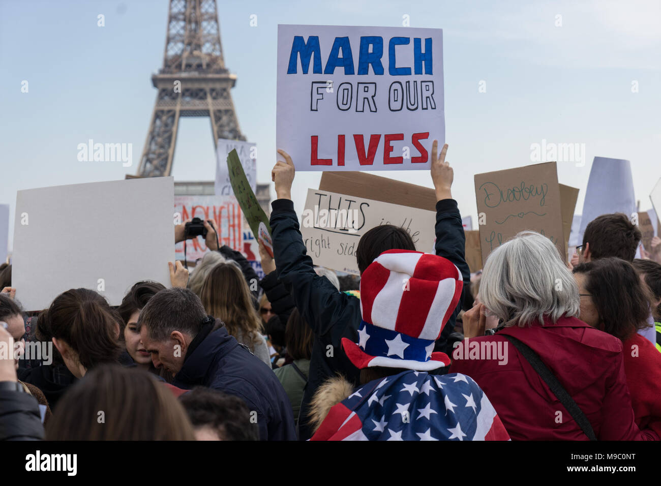 Parigi, Francia. Il 24 marzo 2018. Persone azienda segni contro la violenza pistola durante il mese di marzo per le nostre vite a protestare di fronte alla Torre Eiffel. © David Bertho / Alamy Live News Foto Stock