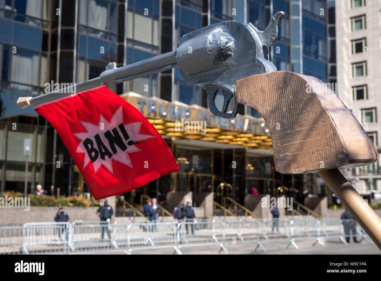 New York, Stati Uniti d'America. Il 24 marzo 2018. Il dimostratore tenere un gigante pistola di cartone con un " Divieto' segno di fronte ad un sistema pesantemente protetti Trump edificio durante un 'Marco per le nostre vite" protesta pistola esigente controllo nella città di New York. Foto di Enrique Shore/Alamy Live News Foto Stock