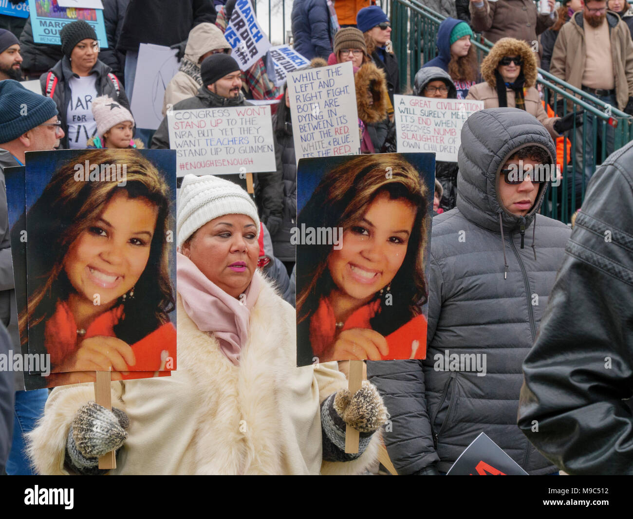 Chicago, Illinois, Stati Uniti d'America. Il 24 marzo 2018. Migliaia di pistola i sostenitori della riforma convergono su Unione Park in questa città del Midwest oggi. Una donna che tiene le foto di una vittima di violenza pistola. Foto Stock