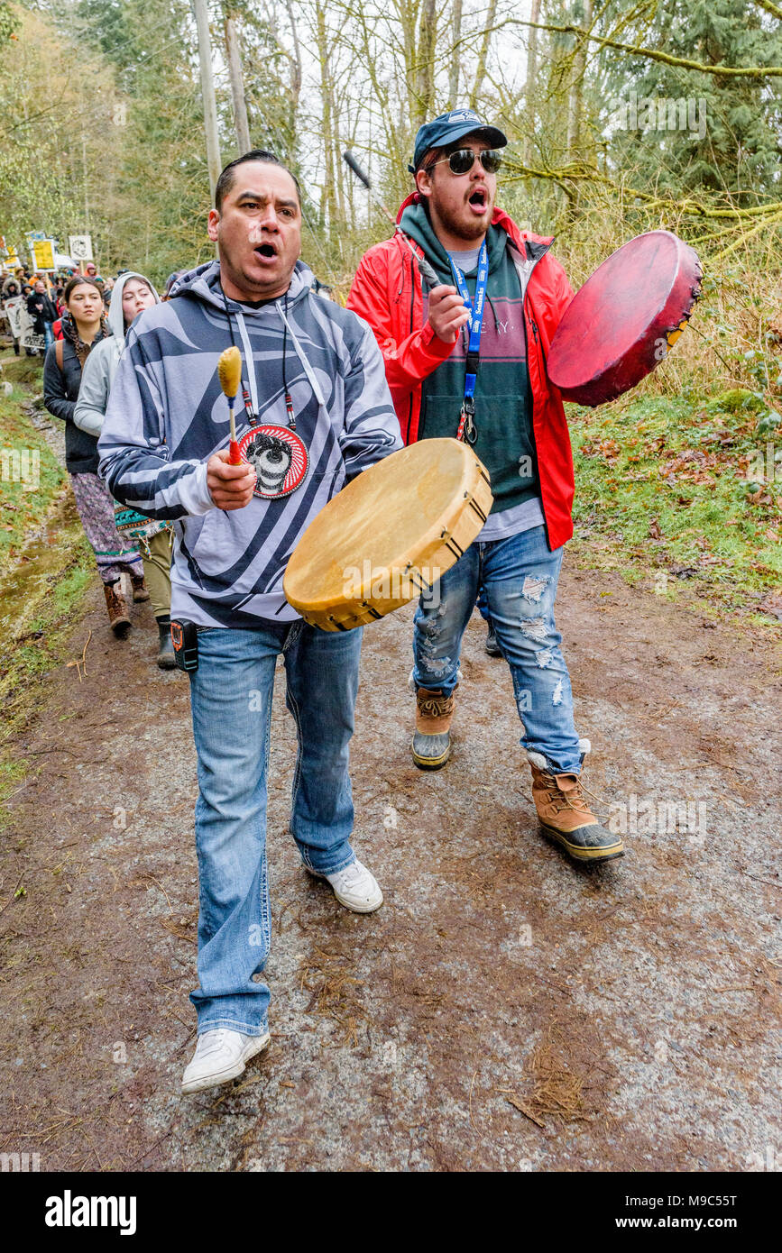 Sarà e cedro George del Tsleil-Waututh prima nazione condurre il più grande gruppo di manifestanti a data verso la Kinder Morgan tubazione ingresso blocco, Burnaby, British Columbia, Canada. Foto Stock
