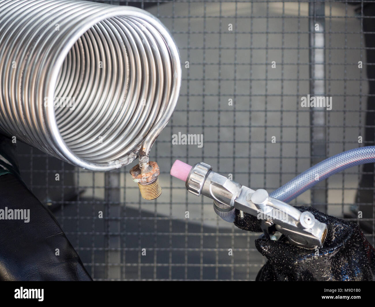 La sabbiatura di uno scambiatore di calore all'interno di una speciale cabina di sabbiatura. Foto Stock