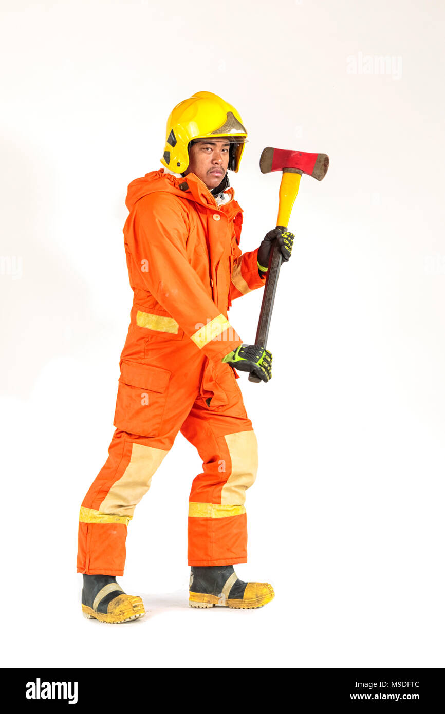 Vigile del fuoco in uniforme e casco di sicurezza in piedi tenendo ax piena lunghezza del corpo Foto Stock