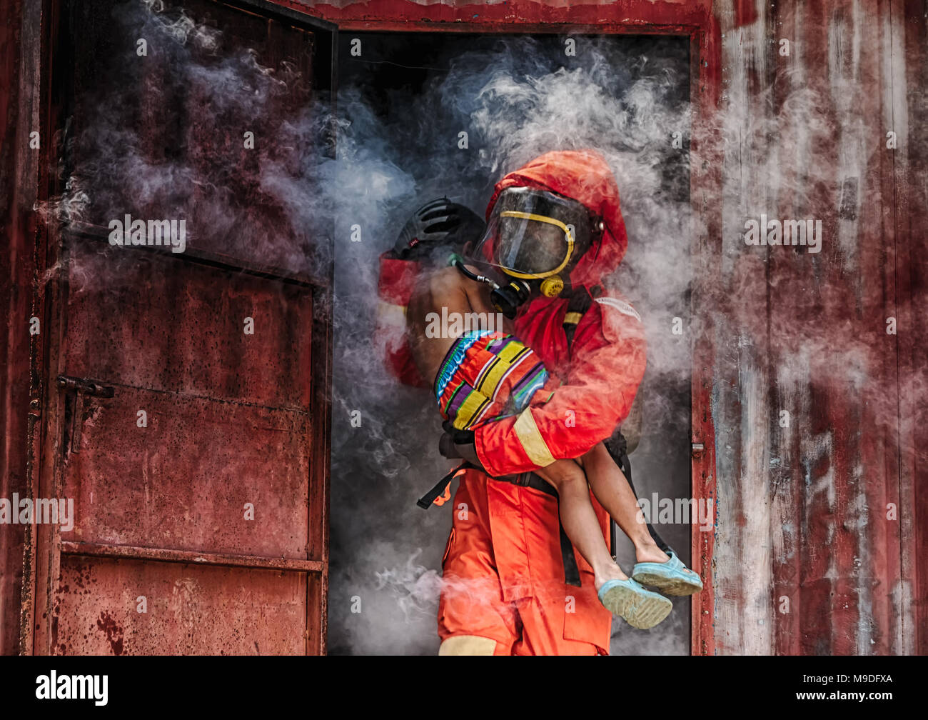 Emergenza antincendio formazione di salvataggio,Vigili del Fuoco salvare il ragazzo dal luogo di bruciato Foto Stock