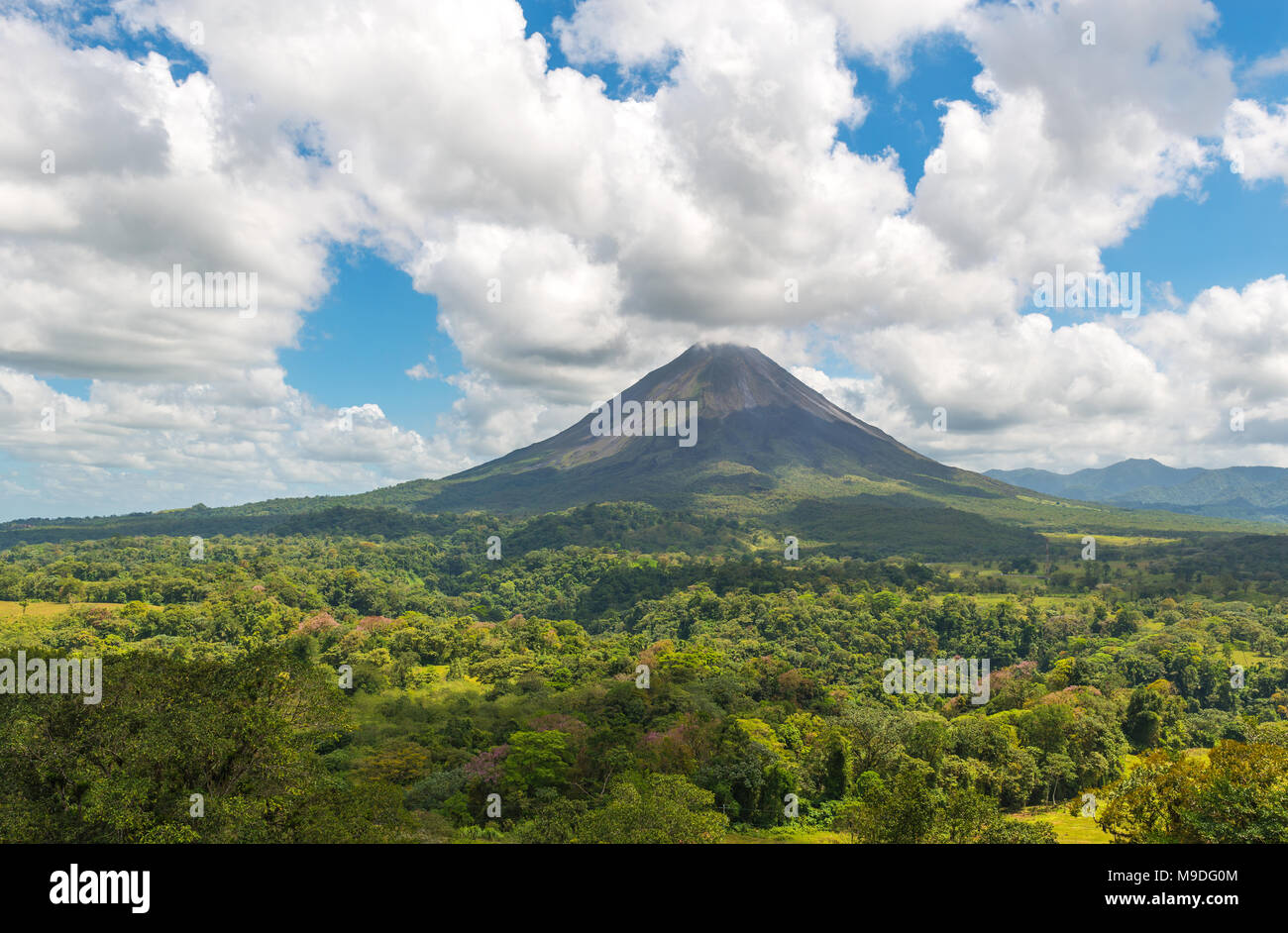 Il paesaggio della foresta pluviale tropicale e la sua calotta del vulcano Arenal ancora attivo in un giorno di estate vicino La Fortuna, Costa Rica, l'America centrale. Foto Stock