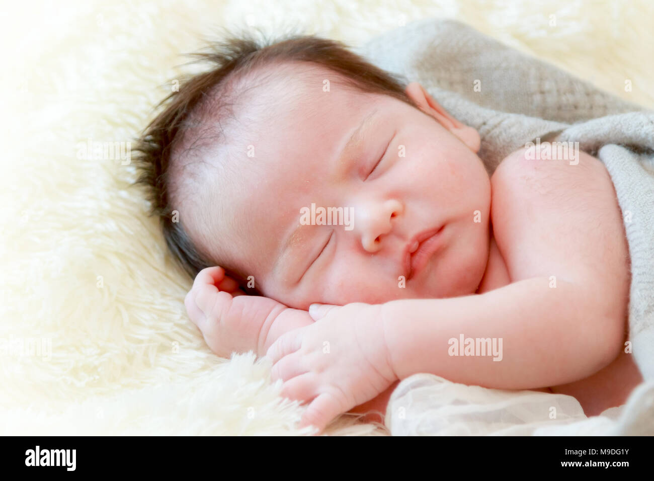 Neonato ragazza dorme sulla coperta di pelliccia Foto Stock