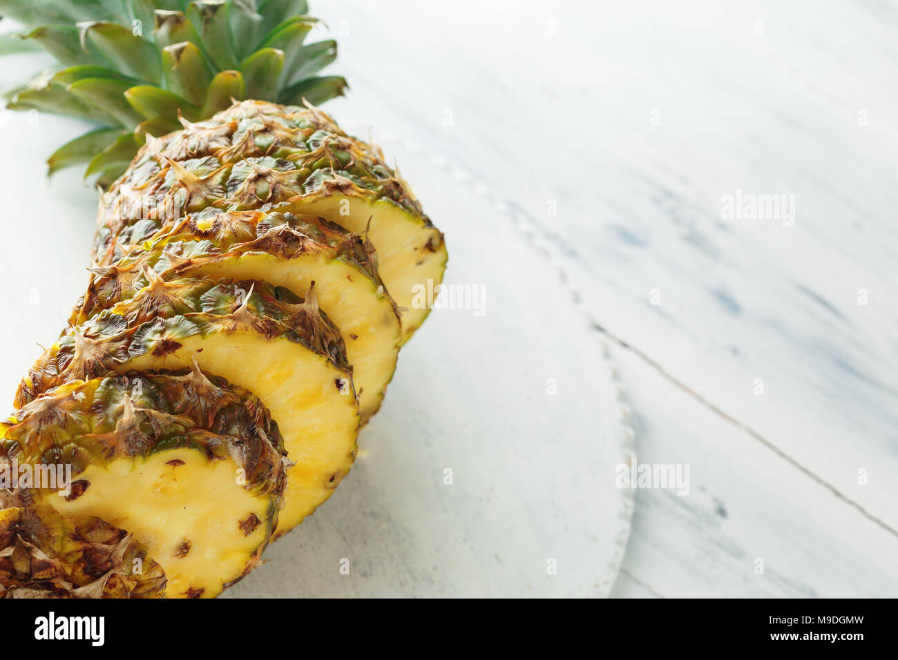 Fresco di ananas a fette in un bianco tagliere di legno. Vista superiore, copia dello spazio per il testo Foto Stock