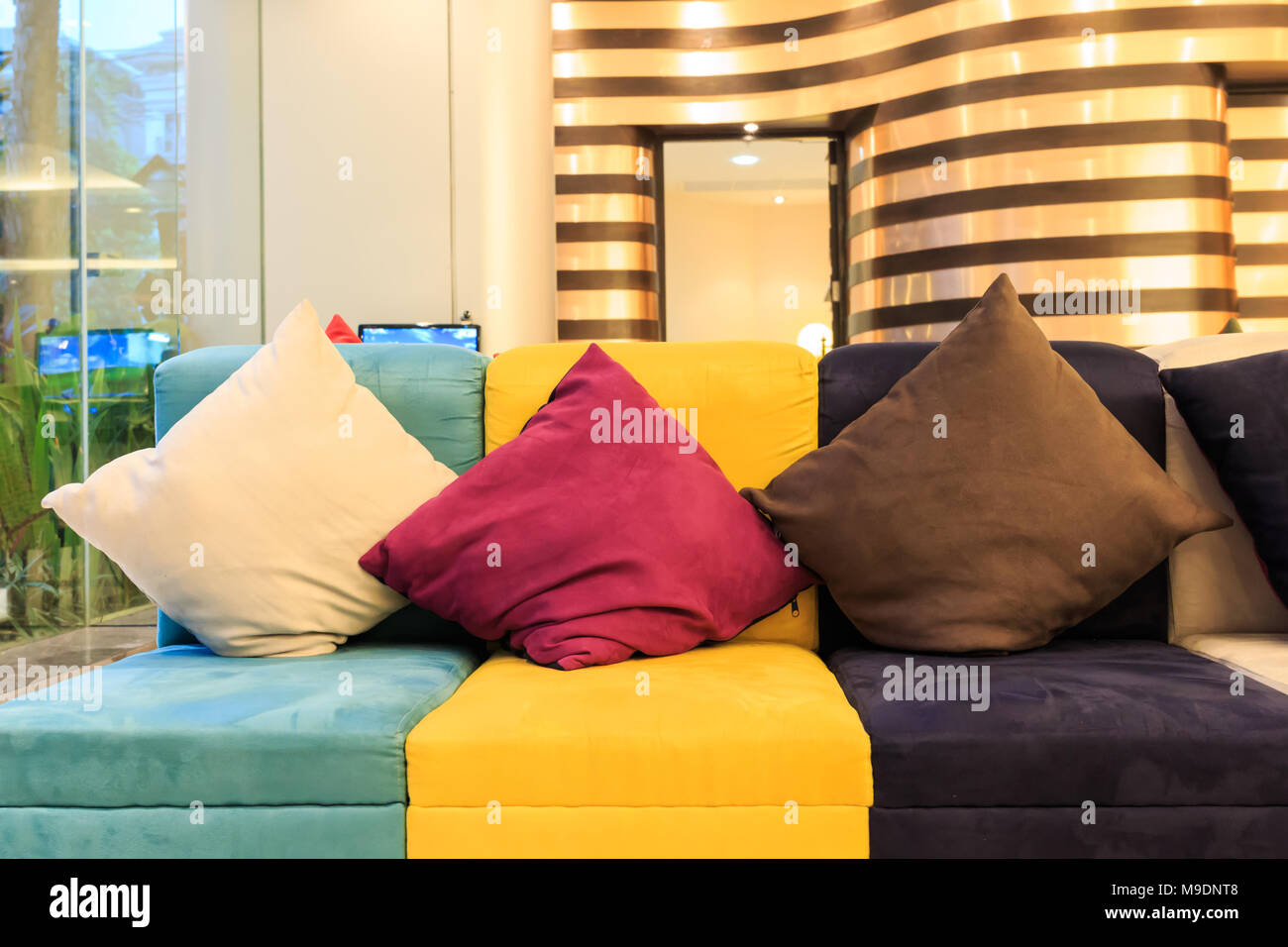 Cuscini decorativi colorati sul divano in pelle Foto stock - Alamy