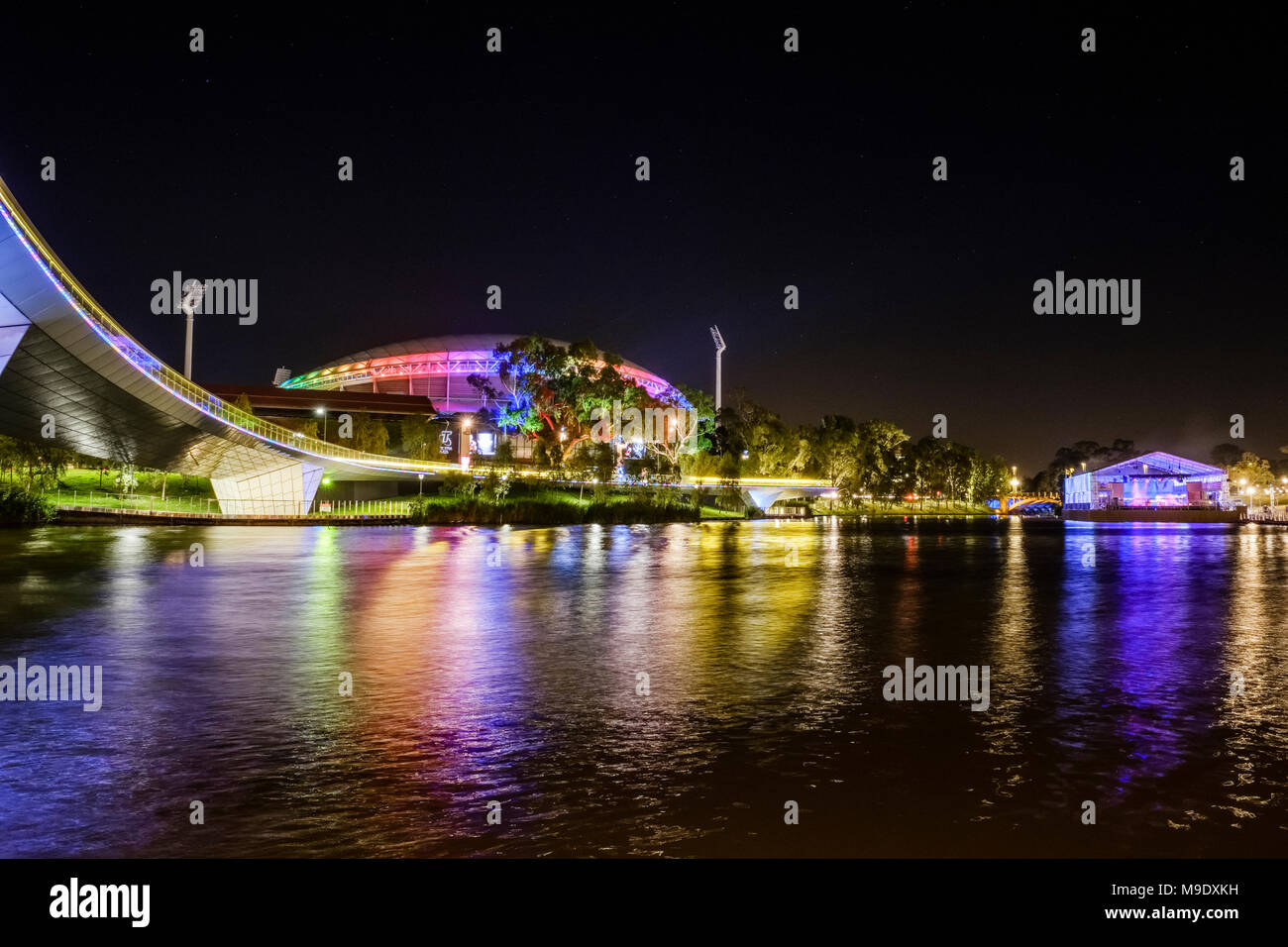 Le luci del Adelaide Oval, Festival Palais e il Footbridge riflettere nel fiume Torrens di notte. Foto Stock