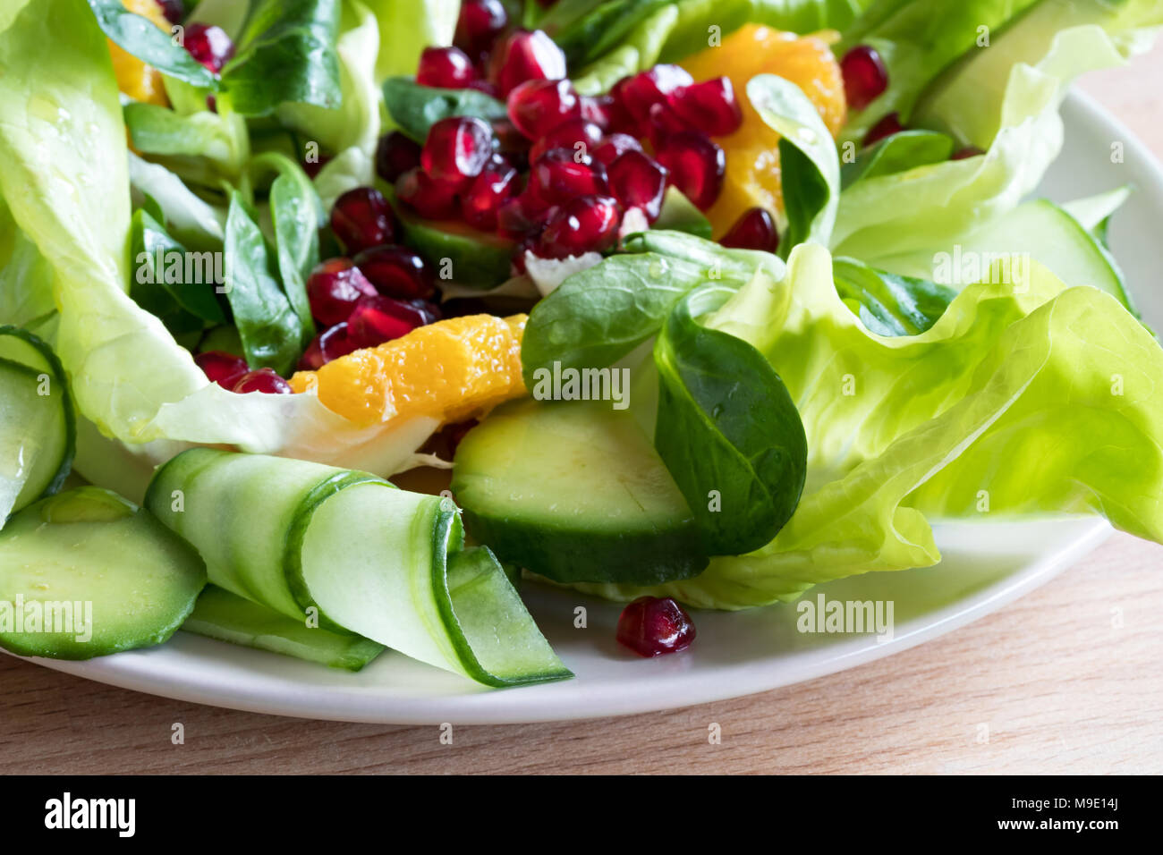 Insalata di verdure con lattuga, lattughella, cetriolo, avocado, arancione e i semi di melograno. Foto Stock