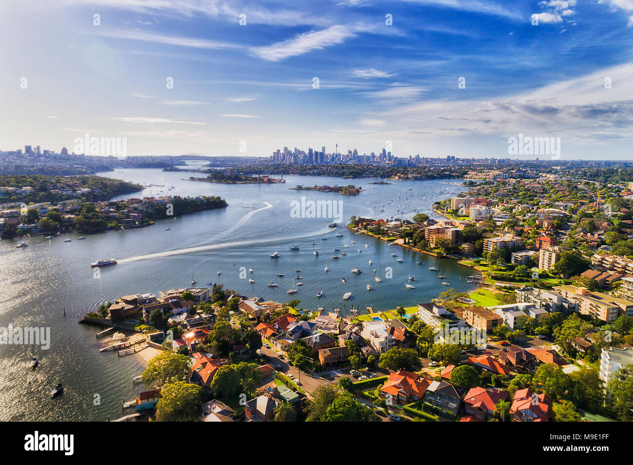 Sydney interna sobborgo occidentale Drummoyne e oltre sulle rive del fiume Parramatta che fluisce nel Sydney Harbour con città lontana CBD sull orizzonte in una elevata Foto Stock